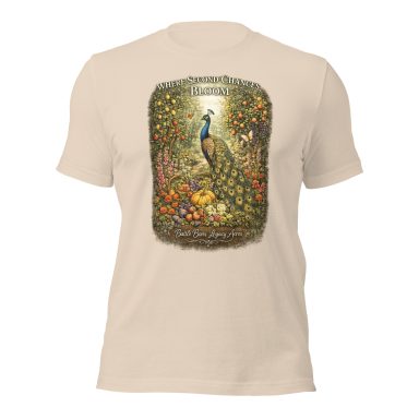 Beige t-shirt featuring a colorful peacock surrounded by flowers and intricate designs.